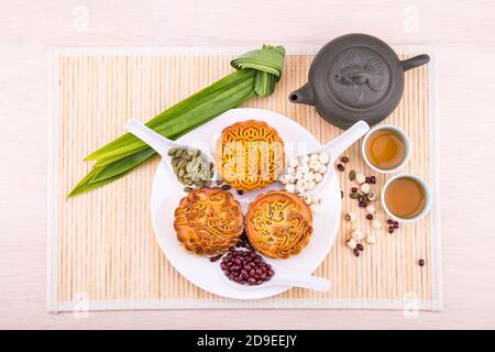 Mooncake per la festa cinese di metà autunno, con ingredienti e tè. Foto Stock