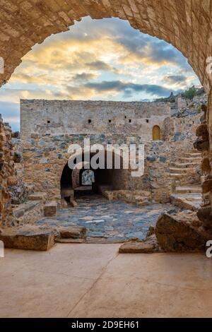 Vista dell'architettura tradizionale e dell'arco di pietra gialla dalla città alta il castello medievale di Monemvasia, Lakonia, Peloponneso. Foto Stock