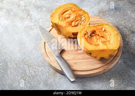 Zucca o zucca della varietà Kamo-Kamo dalla Nuova Zelanda dimezzato su una tavola da cucina, preparazione di cottura per un delizioso piatto d'autunno, spazio copia, se Foto Stock