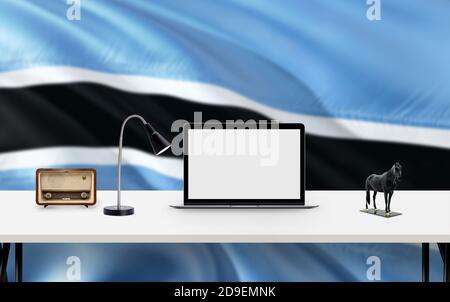 Bandiera nazionale Botswana sfondo con spazio di lavoro, computer desktop e accessori per ufficio su tavolo bianco moderno. Foto Stock