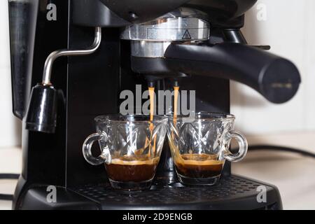 Processo di preparazione di due shot di espresso con la macchina espresso. Caffè italiano. Foto Stock