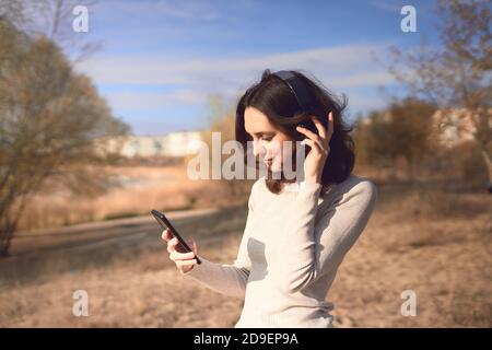 Donna sorridente mentre ascolta la musica Foto Stock