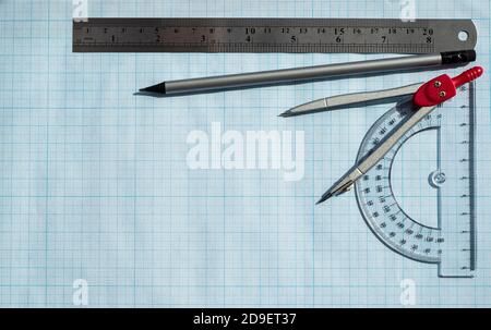 Telaio realizzato con accessori per calcoli e disegno su carta blu. Righello di protactor matita semplice e compassi. Scienze esatte. Foto Stock