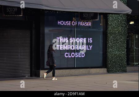 Una donna cammina accanto a un cartello chiuso presso il grande magazzino House of Fraser di Oxford Street il primo giorno del secondo blocco nazionale in Inghilterra. Londra, Regno Unito 5 novembre 2020. Foto Stock