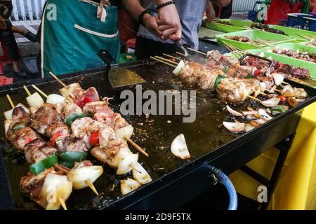 Venditore che prepara pollo kebab alla griglia al mercato per iftar Foto Stock
