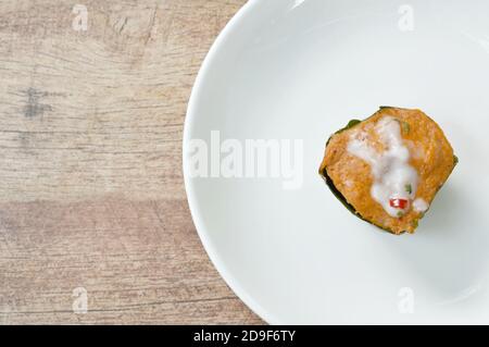 pesce al vapore con pasta di curry fettine ripieni di cavolo in banana vassoio a balestra sulla piastra Foto Stock