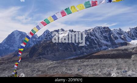 Bandiere colorate di preghiera buddista che volano nel vento forte sulla cima di Kala Patthar, Sagarmatha National Park, Himalaya, Nepal. Foto Stock