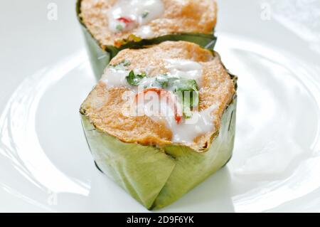 pesce al vapore con pasta di curry fettine ripieni di cavolo in banana vassoio a balestra sulla piastra Foto Stock