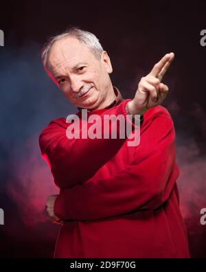 Vecchio riuscito in un maglione rosso gesti Foto Stock