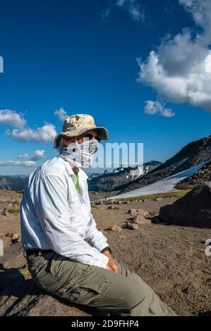 Uomo che indossa la maschera di un escursionista in montagna Foto Stock