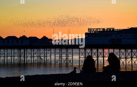 Brighton UK 5 novembre 2020 - il sole tramonta sul molo di Brighton Palace mentre le stelle iniziano le loro murazioni stagionali questa sera come il primo giorno delle nuove restrizioni di blocco del coronavirus in Inghilterra si avvicina: Credit Simon Dack / Alamy Live News Foto Stock