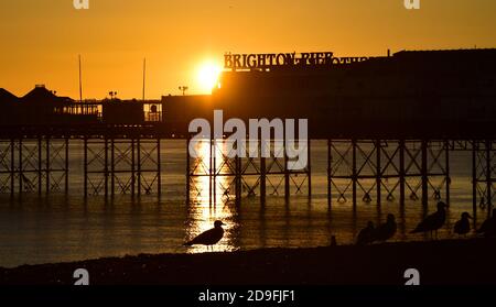 Brighton UK 5 novembre 2020 - il sole tramonta sul molo di Brighton Palace questa sera come il primo giorno delle nuove restrizioni di blocco del coronavirus in Inghilterra si chiude : Credit Simon Dack / Alamy Live News Foto Stock