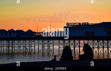 Brighton UK 5 novembre 2020 - il sole tramonta sul molo di Brighton Palace mentre le stelle iniziano le loro murazioni stagionali questa sera come il primo giorno delle nuove restrizioni di blocco del coronavirus in Inghilterra si avvicina: Credit Simon Dack / Alamy Live News Foto Stock