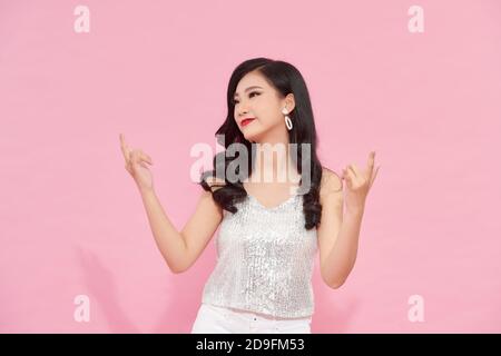 Foto al coperto di adorabile modello femminile in abito scintillante danzante durante l'evento di natale. Foto Stock