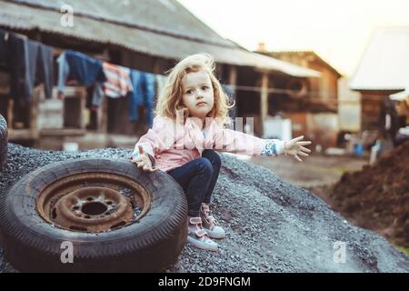 una ragazza gioca in un quartiere povero Foto Stock