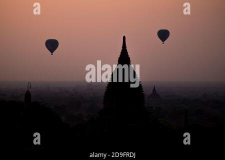 tramonto a bagan con pagoda e mongolfiera Foto Stock