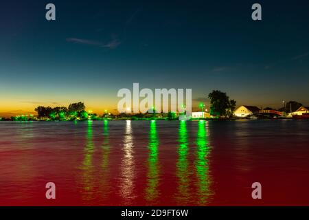 Tramonto su Sulina, Romania con luci che si riflettono nell'acqua. Fotografia del Danubio al tramonto. Foto Stock