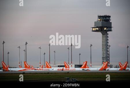 05 novembre 2020, Brandeburgo, Schönefeld: Gli aeromobili della compagnia Easyjet si trovano accanto alla torre del nuovo aeroporto Berlin Brandenburg Willy Brandt (BER). Foto: Bernd von Jutrczenka/dpa Foto Stock