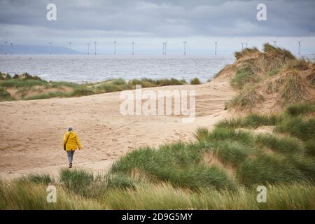Formby Merseyside, Inghilterra. National Trust legno e dune di sabbia fronte spiaggia che si affaccia sulle turbine eoliche nel paesaggio Foto Stock