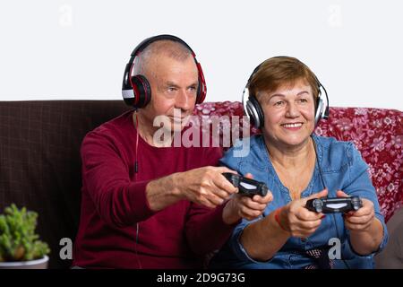Una coppia anziana gioca in una sala giochi a casa con le cuffie e divertirsi. Foto Stock