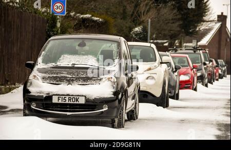 Pontypridd, Galles - Marzo 2018: Le auto sono lasciate sul ciglio della strada dopo una caduta di neve, con dridi neve tra le vetture Foto Stock