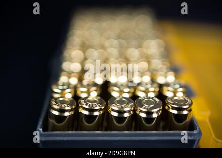 Closeup di una scatola di 9 mm munizioni con un piccolo dept di campo su uno sfondo scuro. pallottole da 9 mm. Foto Stock