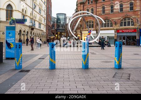Belfast, Irlanda del Nord, Regno Unito, 5 novembre 2020: Cartelli ad Arthur Square che ricordano alla gente di mantenere la distanza. La scultura Spirit of Belfast è sullo sfondo Foto Stock