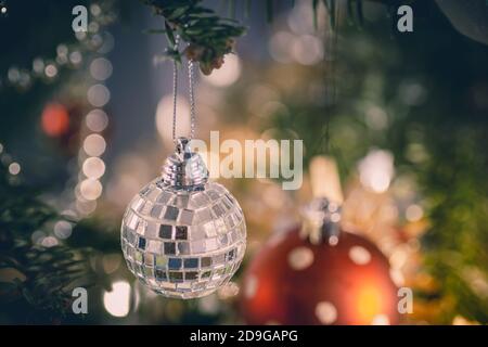 Closeup di baubles rosso e argento appesi all'albero di Natale. Bello sfondo verde e bianco sfocato Foto Stock