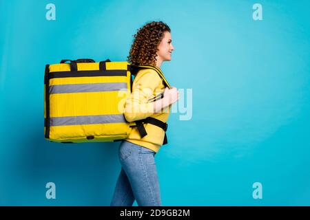 Profilo ritratto vista laterale di lei bella bella allegra allegra una ragazza dai capelli ondulati e fiduciosi che porta il pranzo da asporto isolato luminoso Foto Stock