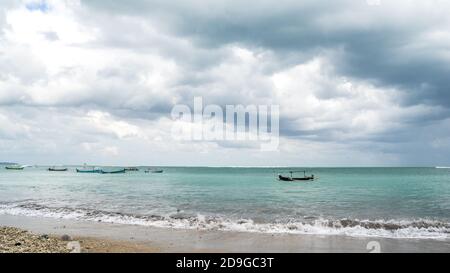 tempesta sul mare, barca da pesca sulla spiaggia. Prima della pioggia in Indonesia, drammatico cielo nuvoloso Foto Stock