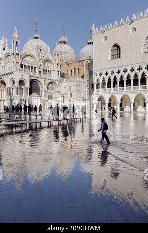 Persone che camminano su passerelle a Venezia, con eccezionale alta marea in Piazza San Marco Foto Stock