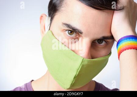 Uomo dagli occhi verdi ispanici che indossa una maschera verde su un bianco sfondo Foto Stock