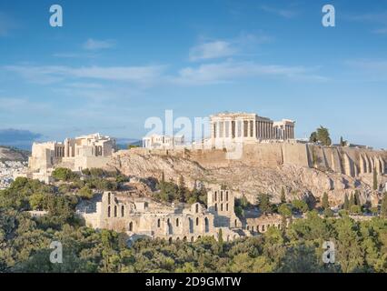 Vista ad Atene sull'Acropoli, Partenone in lontananza contro il cielo blu in prima serata Foto Stock