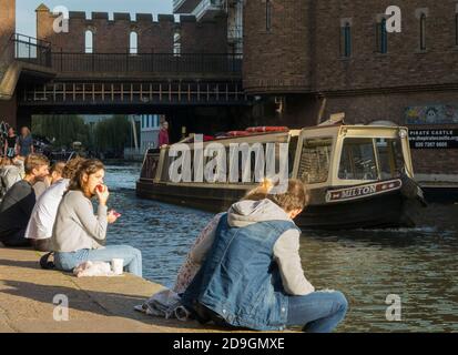 I turisti godono del sole del tardo autunno guardando una barca turistica sul canale di Camden Lock sul canale Regent a Camden, Londra. Foto Stock