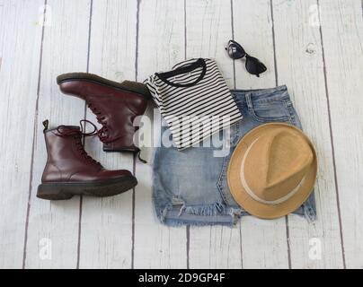 Ancora vita di vestiti con jeans, t-shirt a righe, aereo ... Still life di vestiti con jeans, t-shirt a righe, su uno sfondo bianco di legno Foto Stock