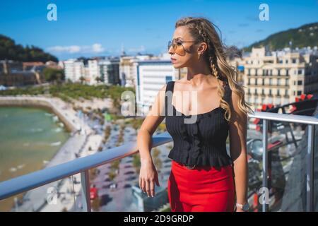Bella donna caucasica bianca in piedi sul balcone del camera d'albergo con vista mare Foto Stock