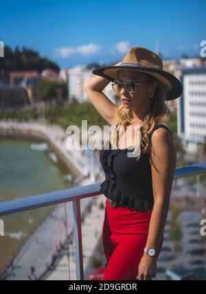 Bella donna caucasica bianca in piedi sul balcone del camera d'albergo con vista mare Foto Stock
