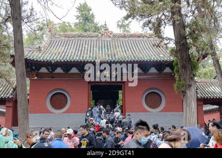 Greggi di visitatori, vestiti con impermeabile di vari colori, visita il Monastero di Shaolin, noto anche come il Tempio di Shaolin, che e il suo Pagoda Forest Wer Foto Stock