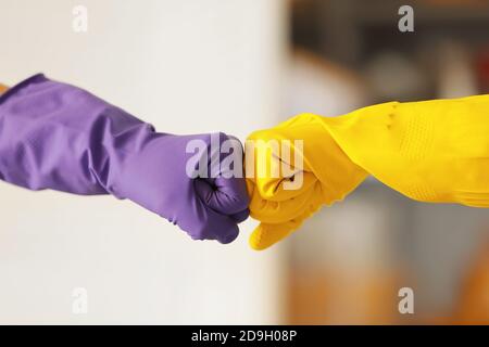 Donne in guanti di gomma che urtano i pugni a casa Foto Stock