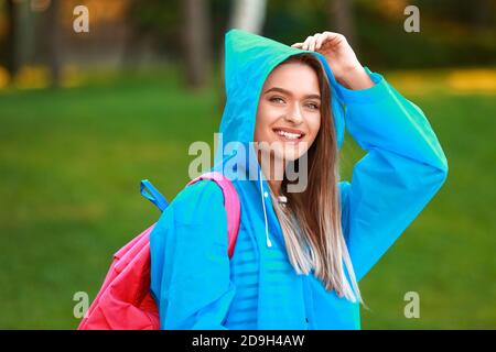 Bella giovane donna con impermeabile nel parco Foto Stock