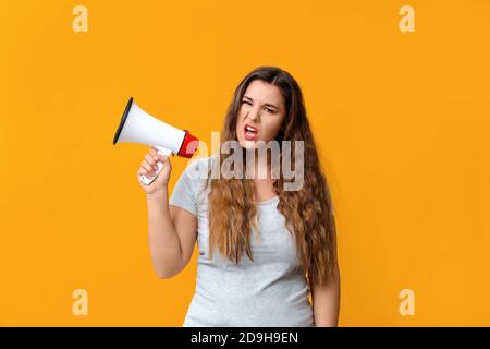 Donna che protesta con il megafono su sfondo a colori Foto Stock