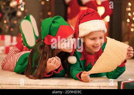 Carino elfi con lettera a Santa a casa Foto Stock