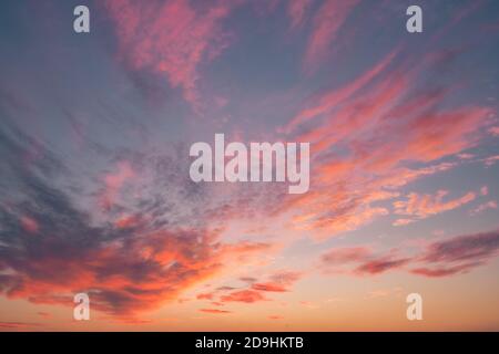 I caldi raggi solari del tramonto colpiscono le nuvole Una serata d'autunno Foto Stock