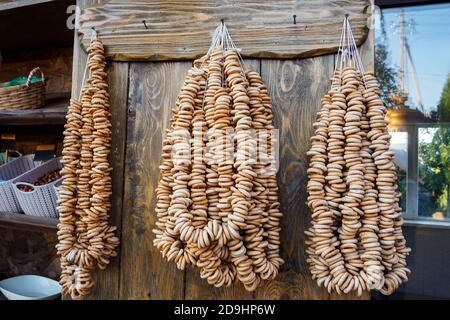 Un sacco di bagel su corde pendono su pareti di legno nel negozio Foto Stock