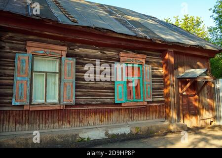 Vecchia casa di legno russa con persiane e porta nella soleggiata giornata estiva Foto Stock