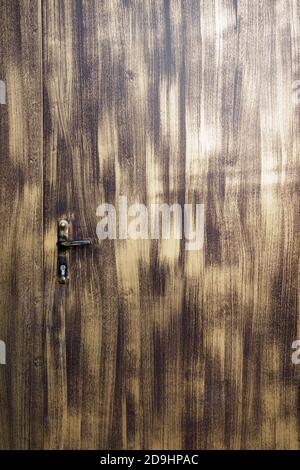 Parte dello sportello in metallo con superficie con pennellate nere su sfondo chiaro, maniglia e toppa. Foto Stock