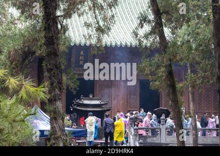 Greggi di visitatori, vestiti con impermeabile di vari colori, visita il Monastero di Shaolin, noto anche come il Tempio di Shaolin, che e il suo Pagoda Forest Wer Foto Stock