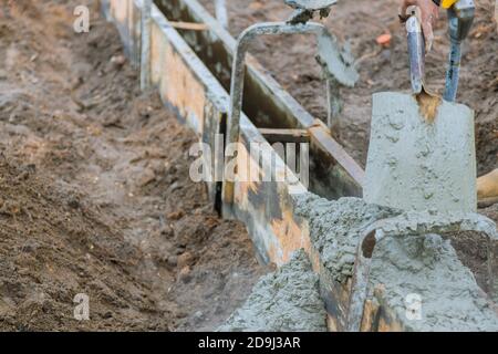 Appaltatore di costruzioni in calcestruzzo che installa un marciapiede, marciapiede su un nuovo progetto urbano stradale Foto Stock