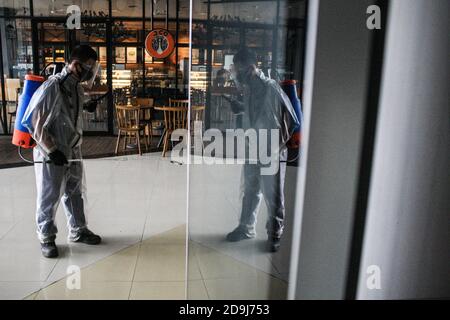 Medan, Indonesia. 06 novembre 2020. Un responsabile della salute vestito con una tuta protettiva spruzza disinfettanti all'interno della Plaza Medan Fair come misura preventiva contro la diffusione del coronavirus. Credit: SOPA Images Limited/Alamy Live News Foto Stock