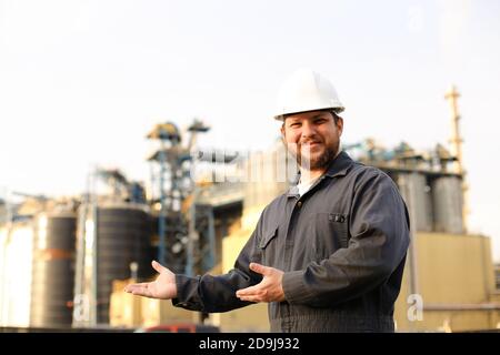 Ritratto di operaio industriale e ingegnere che mostra l'esterno della fabbrica. Foto Stock